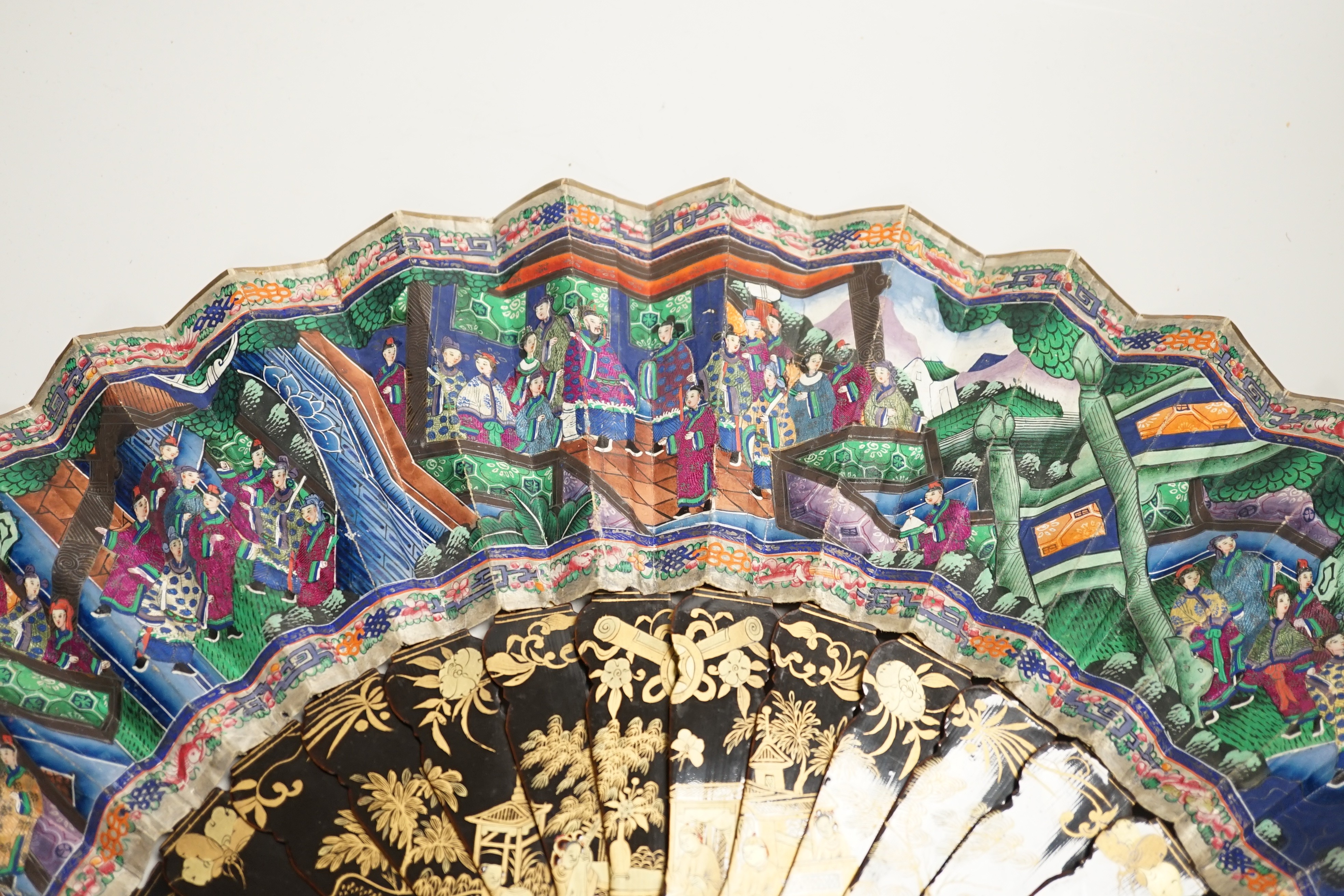 A 19th century Chinese painted paper leaf and lacquer painted fan in a gilt decorated black lacquer fitted case, the fan with painted ivory appliqué faces, 28cm